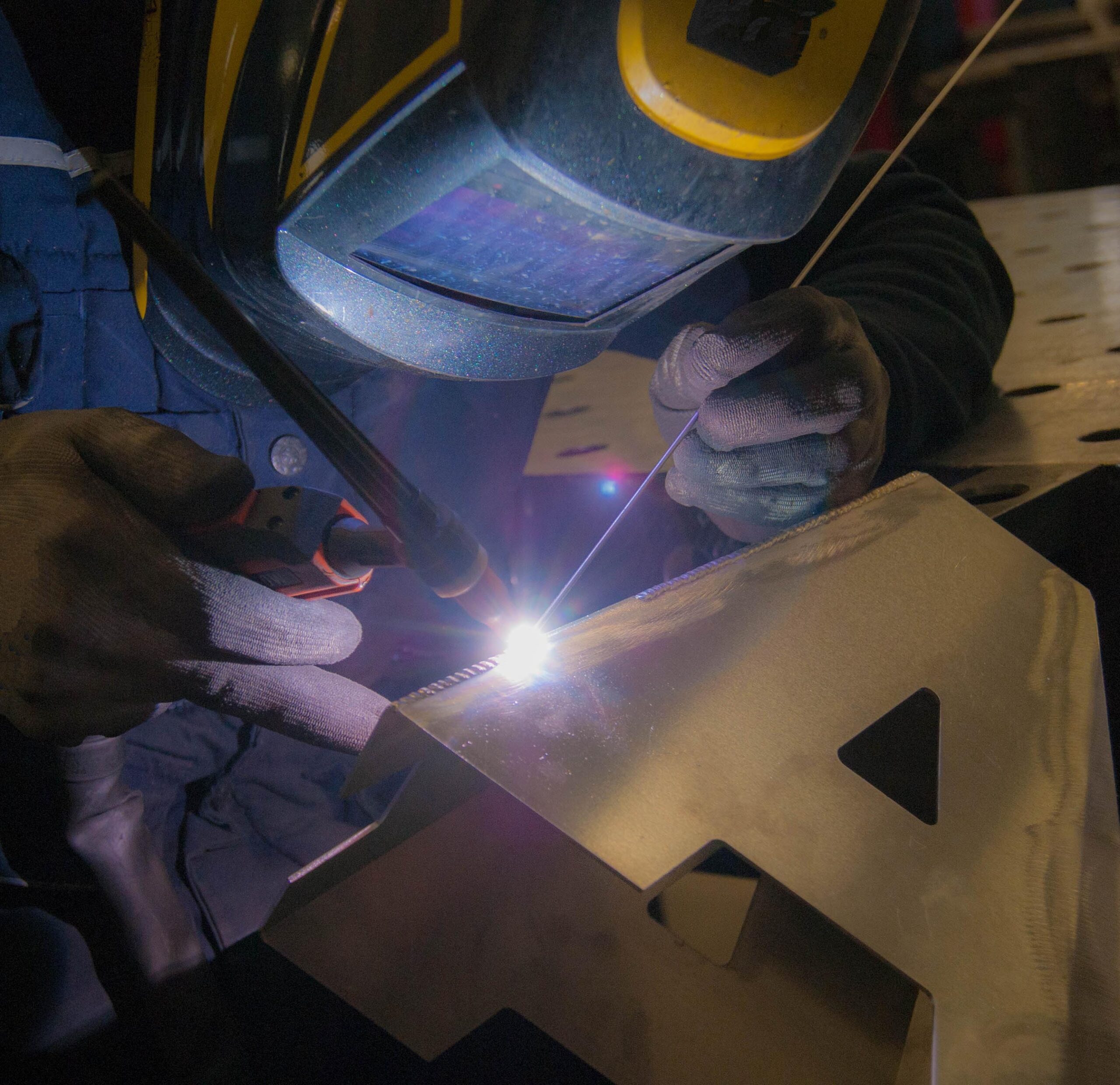 man is welding tig mode an alluminium letter, he is concentrate on his work